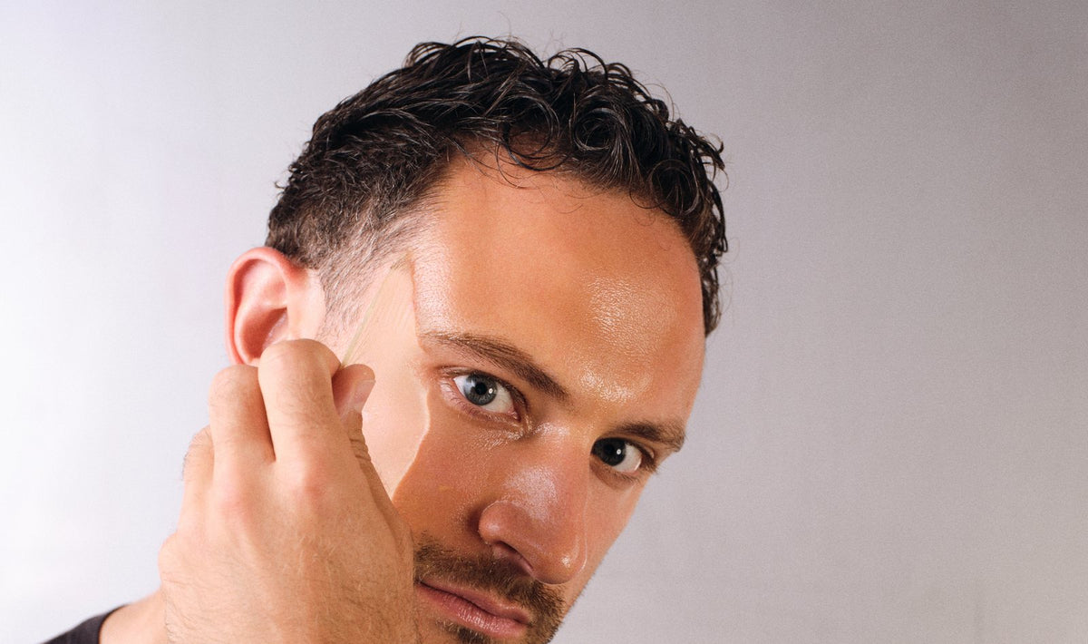 Mann der sich eine Maske abzieht