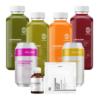 Das DALUMA BESSERE SAFTKUR PLUS - 7 TAGE Set besteht aus kaltgepressten Bio-Säften, adaptogenen Kombucha-Dosen, einem Wellness-Shot und Gesundheitspaketen - alles auf weißem Hintergrund.