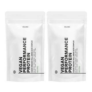 Zwei weiße wiederverschließbare Beutel mit der Aufschrift VEGANES PERFORMANCE PROTEIN NEUTRAL DOUBLE von DALUMA stehen Seite an Seite. Das minimalistische Design weist einen fetten schwarzen Text auf und unterstreicht diese pflanzliche Proteinquelle für den Muskelaufbau mit einem kleinen Neutral-Geschmacksetikett.