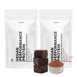 Zwei weiße, wiederverschließbare Beutel mit DALUMA VEGANES PERFORMANCE PROTEIN KAKAO DOUBLE stehen aufrecht und präsentieren diese vegane Bio-Proteinmischung mit minimalistischem schwarzem Text und dem Hinweis "Rohkakao" am Boden.