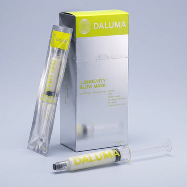 Eine Packung mit 5 Stück der DALUMA LONGEVITY GLOW MASKE – einer Peel-off-Gesichtsmaske – einschließlich zweier einzelner Applikatoren im Spritzenformat.