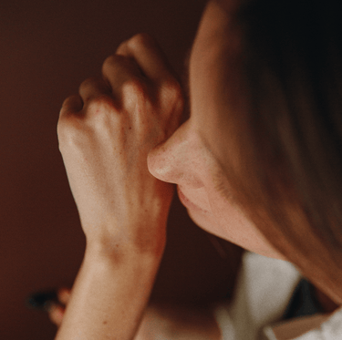 Eine Nahaufnahme des Gesichts und der Hand einer Person, die ihre Stirn nachdenklich auf die Faust stützt, vor einem dunklen Hintergrund, mit dem NULLPUNKT GRADE 0.4 REFUEL von Nullpunkt.