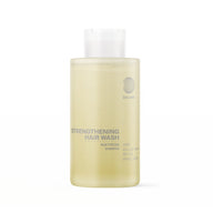 Eine durchsichtige Flasche DALUMA STRENGTHENING HAIR WASH FEUCHTIGKEITSSHAMPOO mit einer weißen Kappe. Die hellgelbe Formel enthält Hanf, Weidenrinde, Brennnessel und Weizenkeime, um die Kopfhaut zu beruhigen und Feuchtigkeit zu spenden.